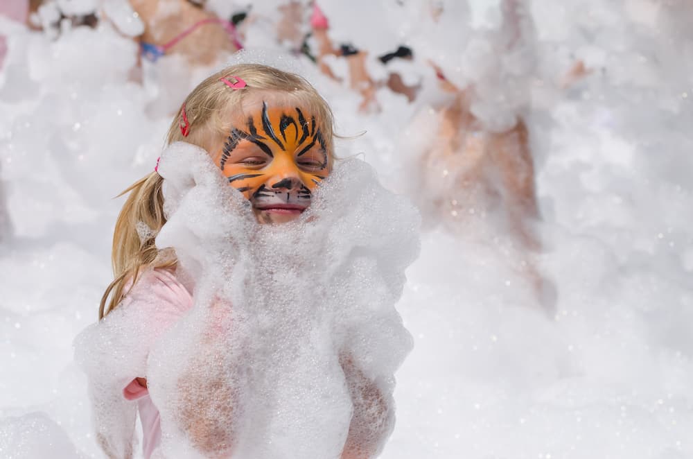 A girl with face paint at a foam party